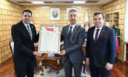 KAGİSAD Başkanı Cemal Sarı KSÜ Rektörü Taner Beye İstiklal Marşı tablosunu takdim etti.